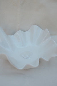 Close-up of a white ruffled fabric edge on a light background